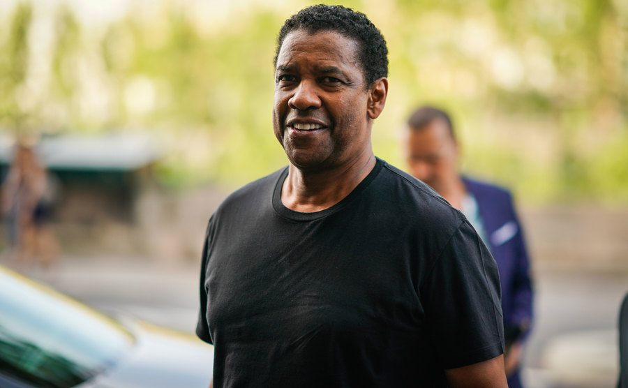 A picture of Denzel Washington walking the street.