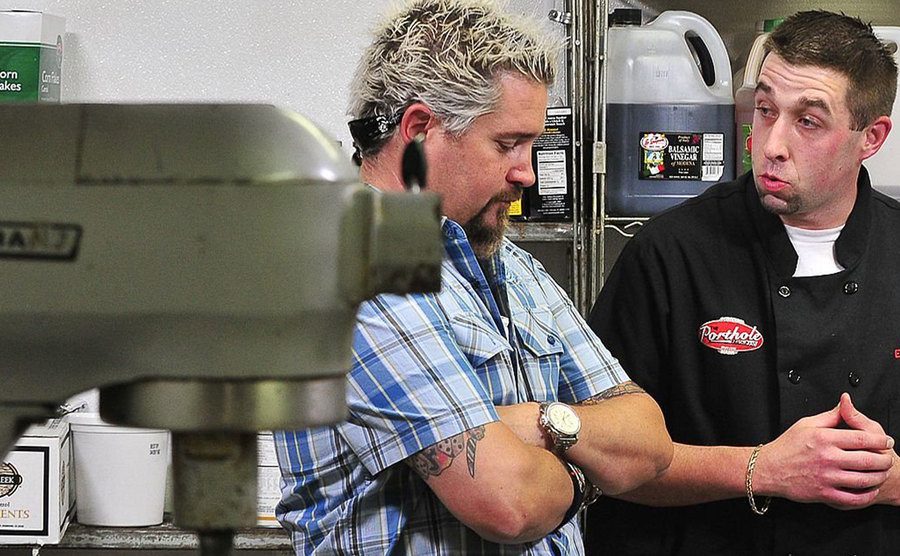 An image of Fieri talking to another chef behind the scenes.