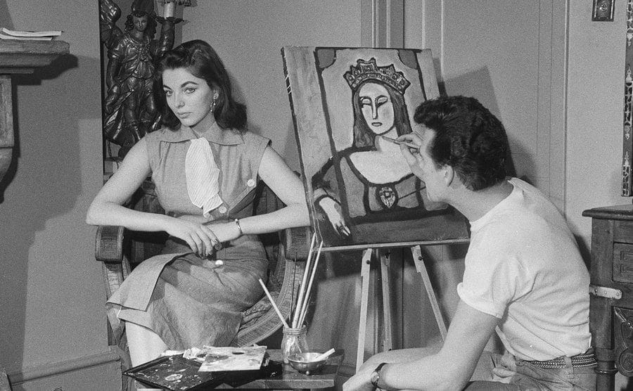 Maxwell Reed paints a portrait of Joan Collins at home. 