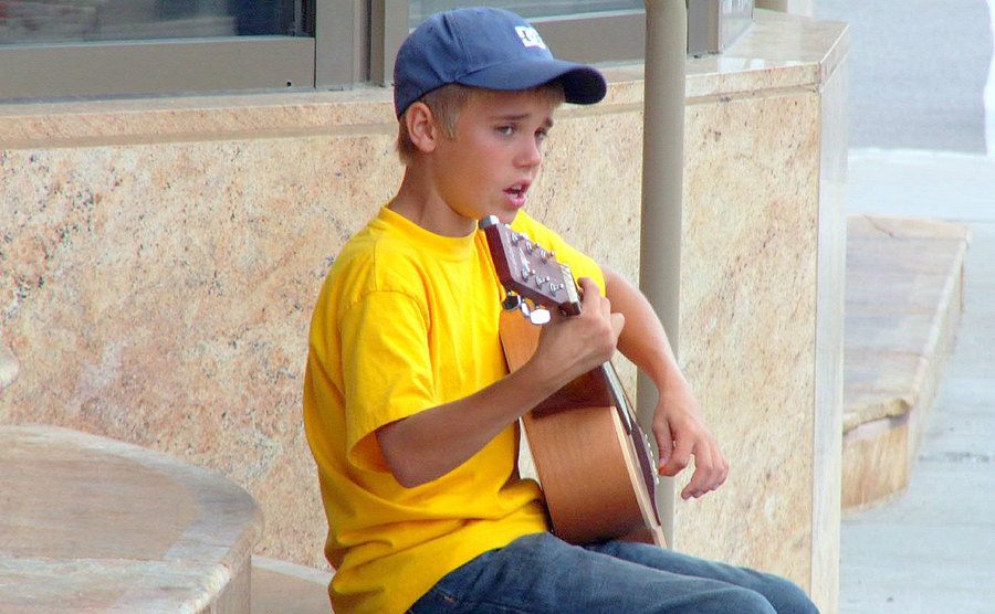 Justin plays his guitar on the steps of the Avon Theater. 