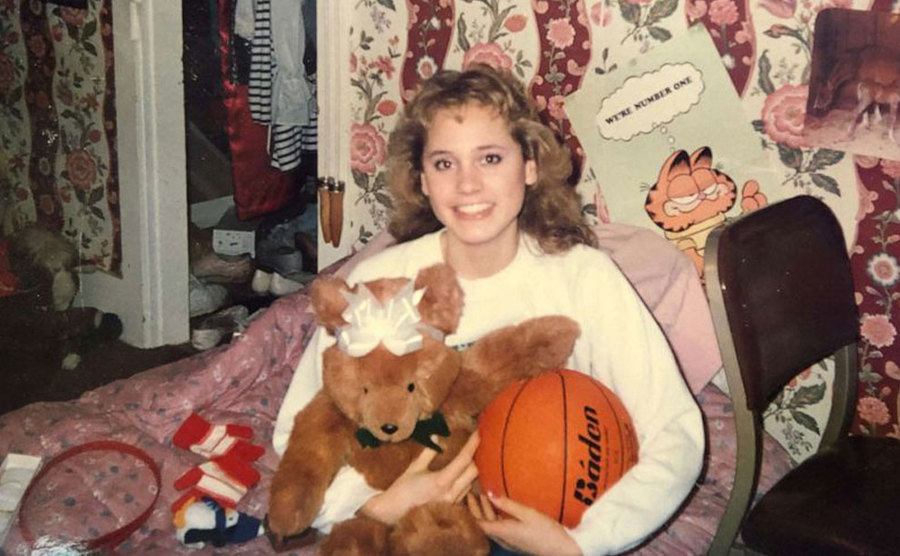 A dated picture of Mandy sitting in her bedroom.