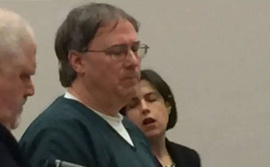 A video still of Tim Bass standing in court.