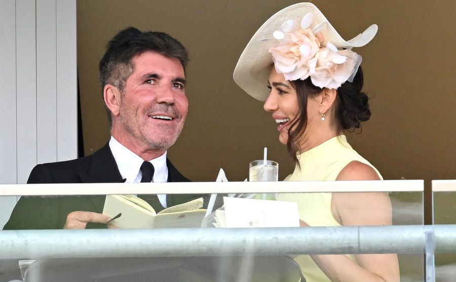 A photo of Cowell and Lauren Silverman standing on a balcony.