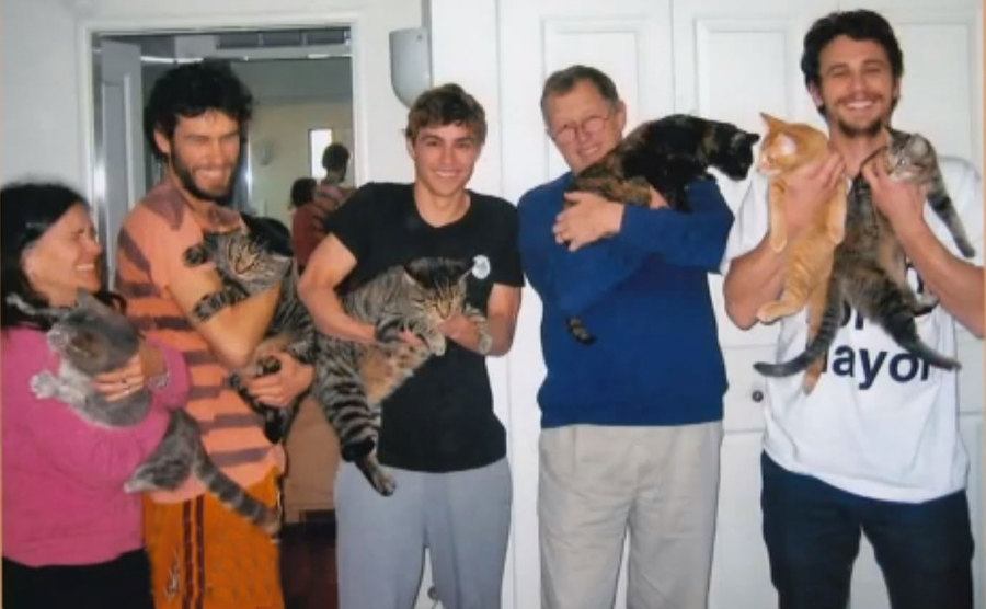 The Franco family poses with their cats. 