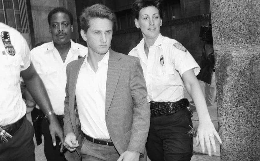 Three court officers escort actor Sean Penn to his arraignment