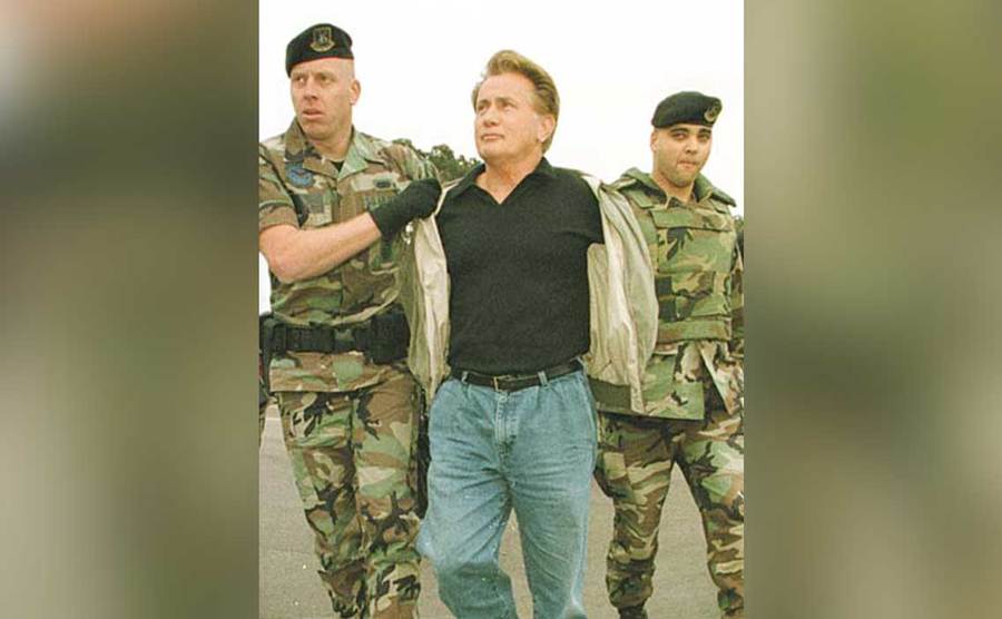 Martin Sheen is escorted by soldiers following his arrest. 