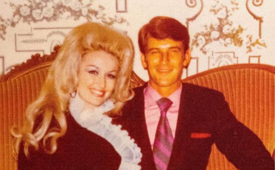 Dolly Parton and Carl Dean pose together on the couch. 