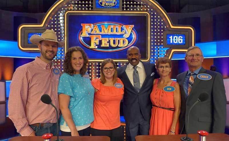 A family of contestants pose with Steve Harvey on set. 