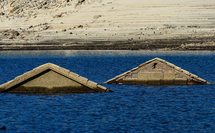 A photo of the roofs of houses from a submerged village in Spain.
