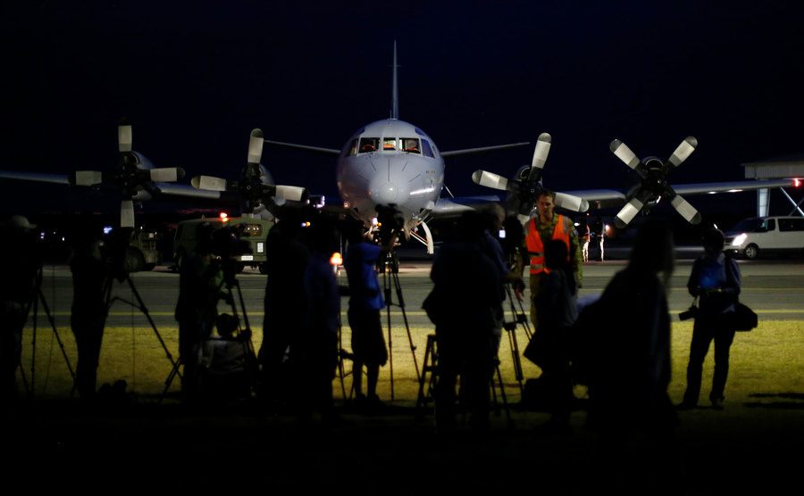 International press gathers around a Malaysian plane at the terminal.