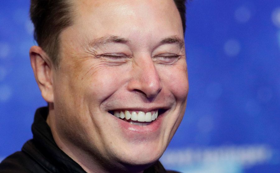 Musk smiles to the press.
