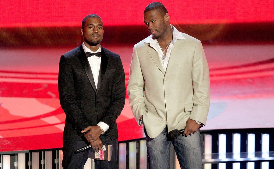 Kanye West and 50 Cent present on stage. 