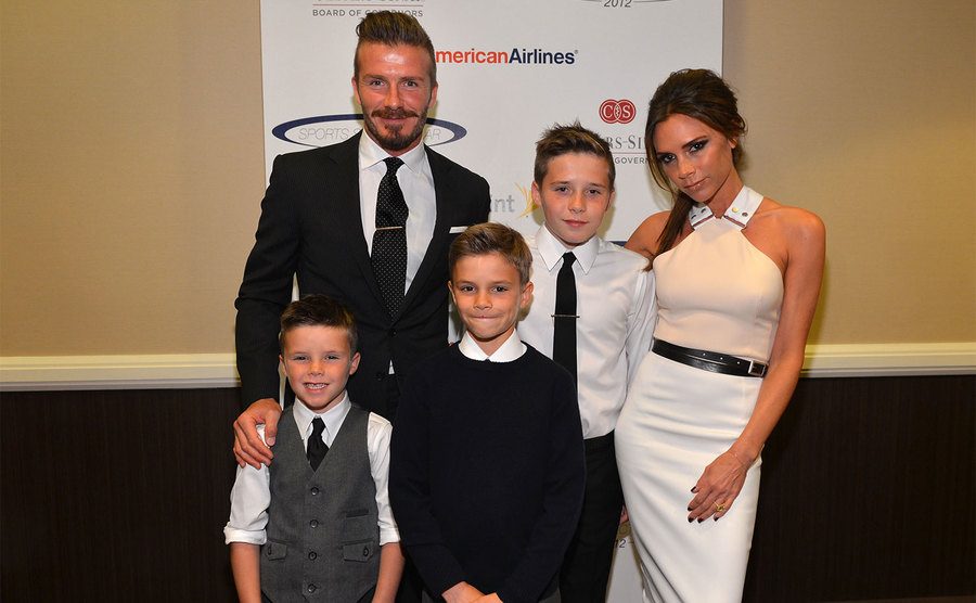 David, Victoria, and their kids pose at an event. 